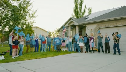 A community group holding blue flags in front of a residential home during the Bighorn Roofing 'Check Your Roof' music video campaign in Utah.